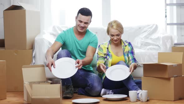 Smiling Couple Unpacking Boxes With Kitchenware 3