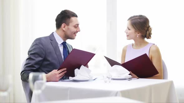 Smiling Couple With Menus At Restaurant 1