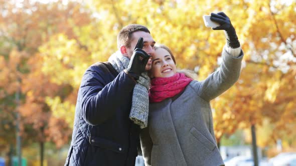 Smiling Couple With Smartphone In Autumn Park 1