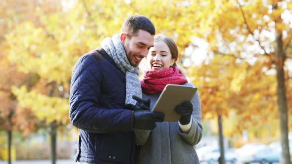 Smiling Couple With Tablet Pc In Autumn Park 3