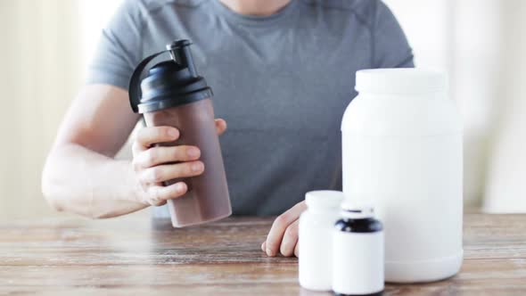 Close Up Of Man With Protein Shake Bottle And Jars 1