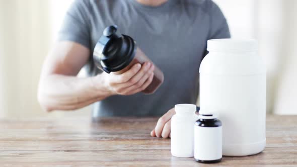 Close Up Of Man With Protein Shake Bottle And Jars 2 alt