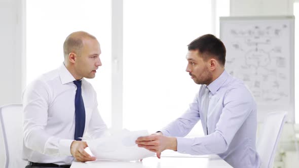 Two Serious Businessmen With Charts In Office 10