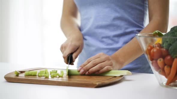 Close Up Of Young Woman Chopping Celery At Home 1