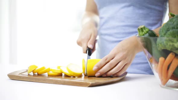 Close Up Of Young Woman Chopping Squash At Home 2