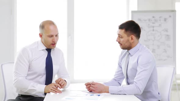 Two Smiling Businessmen With Charts In Office 3