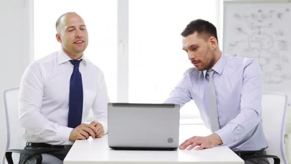 Two Smiling Businessmen With Laptop In Office 1