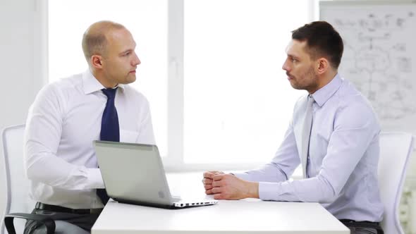 Two Smiling Businessmen With Laptop In Office 5 alt