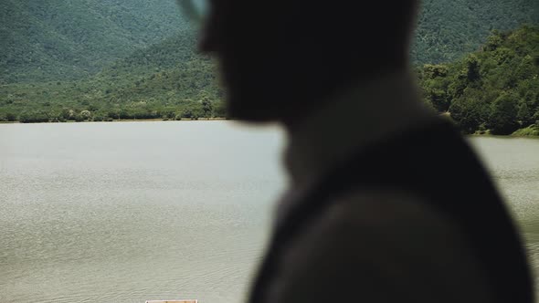 Morning of the Groom Closeup Groom Wearing Bowtie the Silhouette of a Man Admires the Panorama of