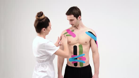 Shoulder treatment with kinesio tape. Physiotherapist applying elastic therapeutic tape