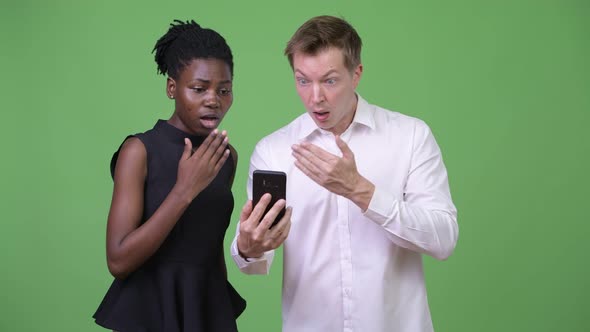 Two Young Multiethnic Business Couple Using Phone Together