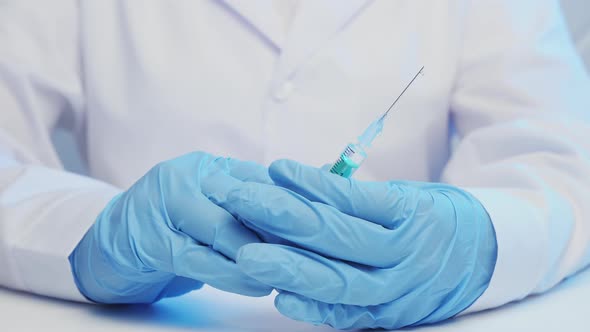 Medic in Gloves Hold a Syringe with a Drug Closeup