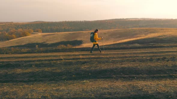 Aerial View Woman Hiking on Road of the Mountain Silhouette in Beautiful Sunset