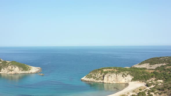 Aerial drone video of semicircular sandy beach and lagoon of Voidokilia