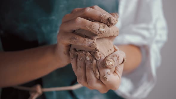 a Woman Potter Wearing an Apron Preparing and Rolling Clay