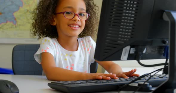 Schoolgirl using desktop pc in classroom at school 4k