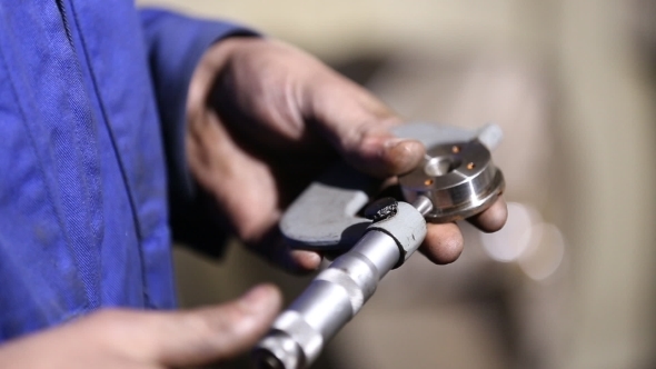 Worker The Item Is Measured With a Micrometer