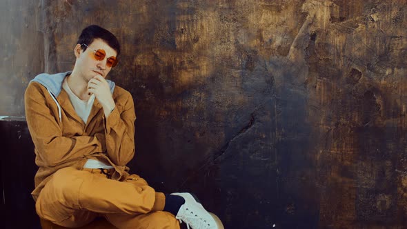 Young Handsome Man in Glasses Sitting on Chair and Looking Away