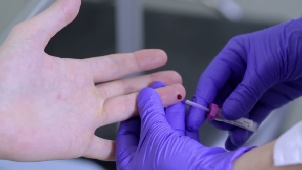 Drawing Blood Sample From Finger In Test Tube