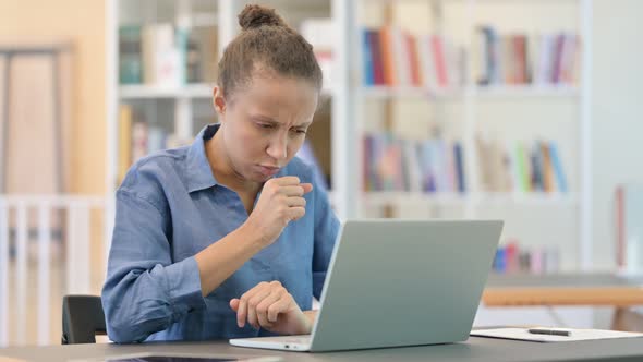 Sick African Woman with Laptop Coughing in Library