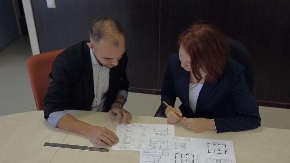 Male And Female Professionals Working Together On