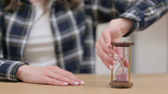 Female Hands Turning Over an Hourglass Close Up