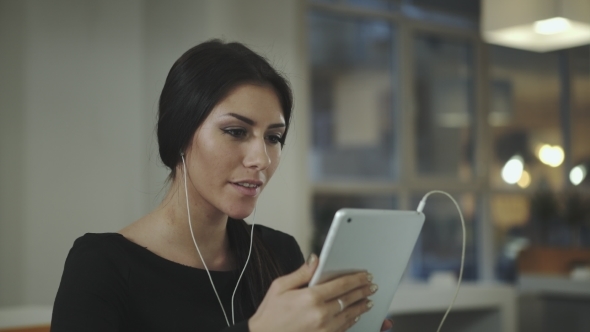 A Woman In The Office Talking With a Tablet