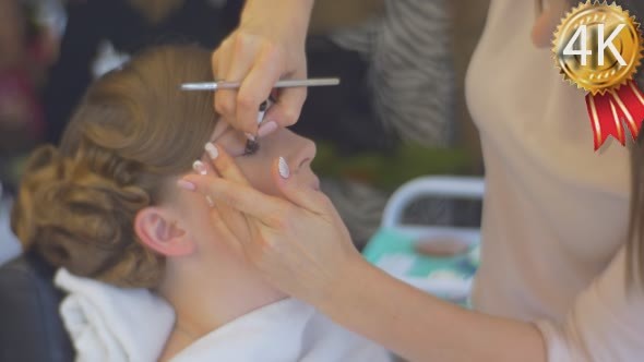 Stylist is Putting an Eyeshadow Making a Makeup