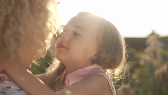 Closeup of Happy Daughter Rubbing Noses with Mother Kissing Parent in Slow Motion