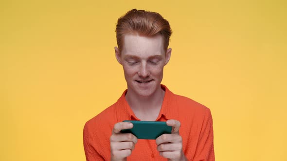 Carefree Man Playing Games on Modern Smartphone