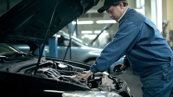 Serviceman Inspecting The Car Engine alt