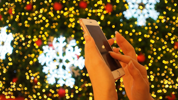 Using Smartphone At Christmas Tree