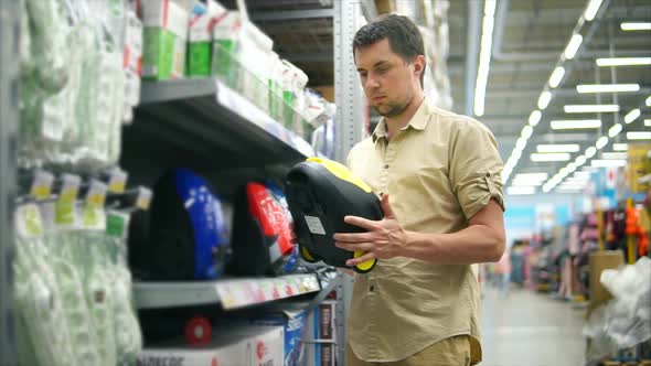 Man Choosing Vacuum Cleaner in the Mall for His Wife