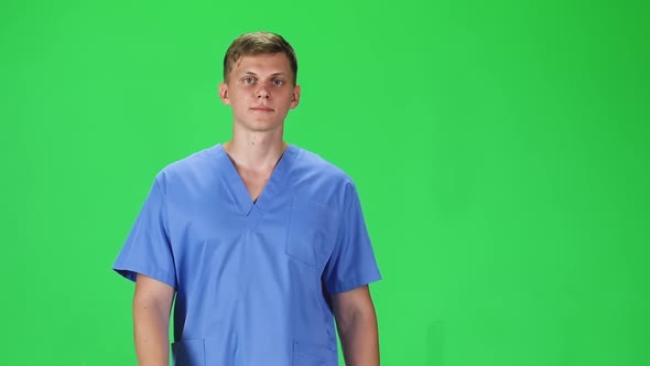 Medical Man Going and Looking Forward Against a Green Background, Slow Motion