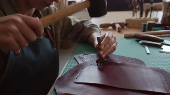 Artisan Making Holes in Leather Bag