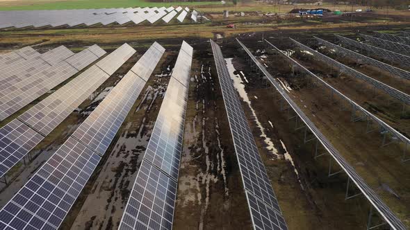 Panning shot with drone over muddy solar power plant