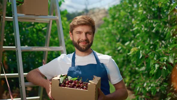 Gardener Holding Fresh Organic Berry Box in Big Summer Garden