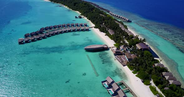 Wide overhead tourism shot of a white sandy paradise beach and blue water background in 4K