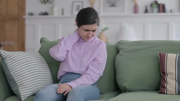 Indian Woman having Neck Pain while Sitting on Sofa