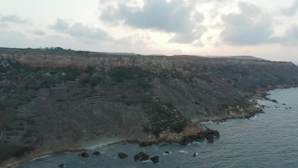 Shoreline of Gozo Malta Island at Sunset, Ocean Waves From Aerial Drone Perspective