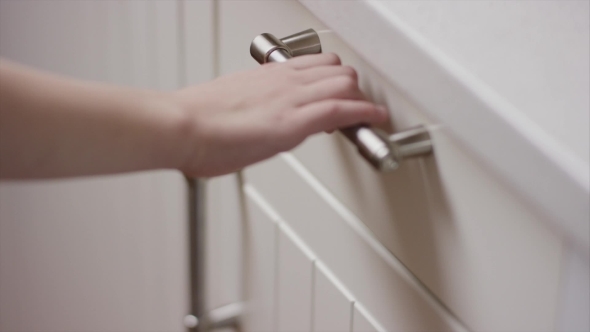 Hand Opens a Kitchen Drawer