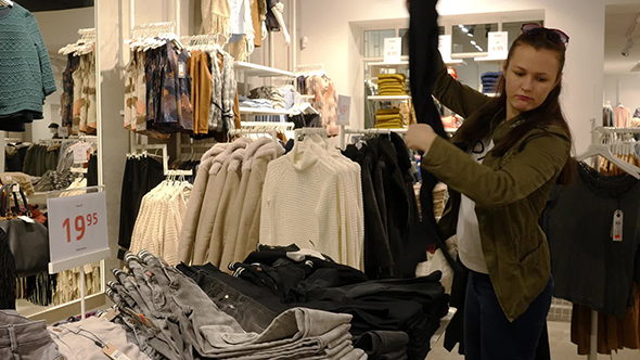 Woman Choosing Clothes During Shopping alt