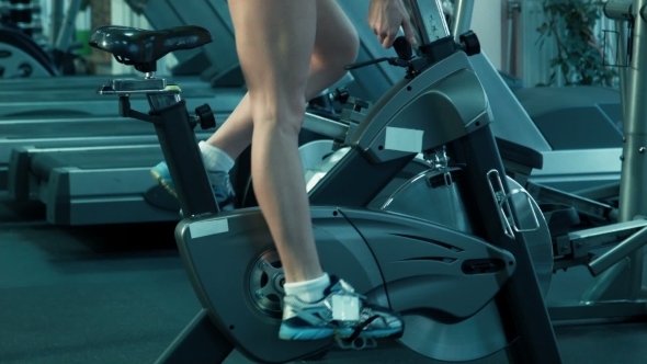 Athletic Female Pedaling On The Simulator On a