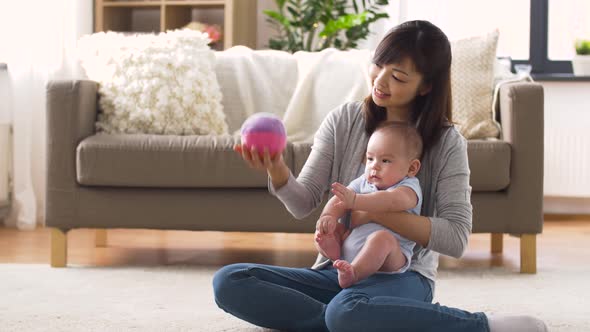 Happy Mother with Baby and Ball Playing at Home