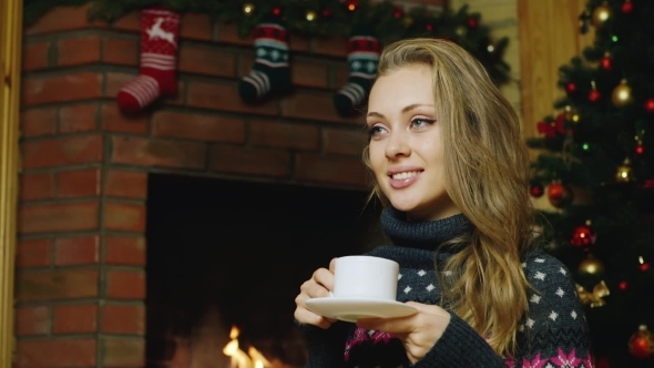 Woman Drinking Tea Near The Fireplace