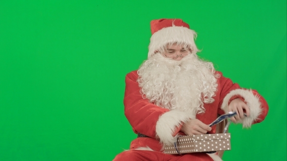 Santa Claus Holding Christmas Gifts On a Green