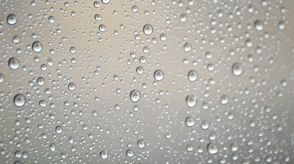 Raindrops Sliding Down the Glass Window of a Room