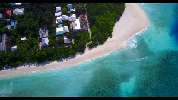 Aerial drone shot scenery of tropical seashore beach time by blue water with white sandy background 