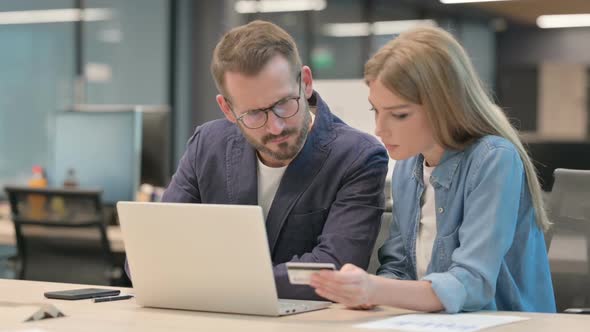 Male and Female Professionals Having Online Payment Failure on Laptop