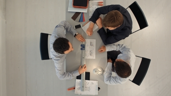 Top View Of Business Team Discussing Blueprint Of